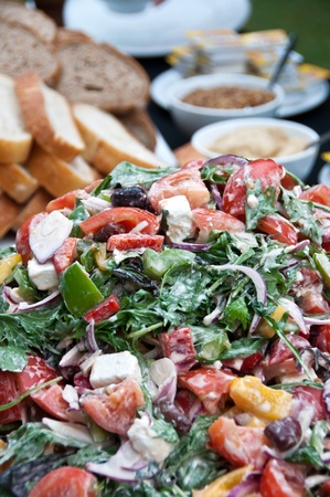 Mixed dressed green salad with bread selectionの写真素材