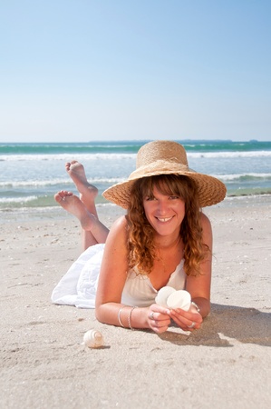 Woman at the beach holding shellsの写真素材