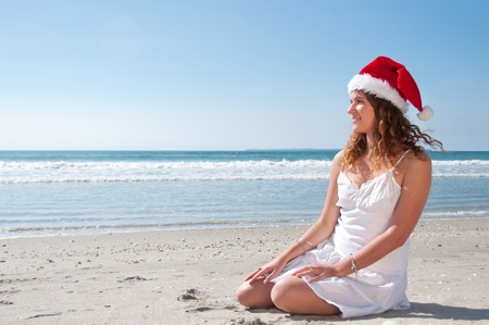 Woman in santa hat at the beachの写真素材