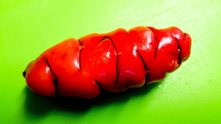 Single red yam on a green cutting boardの素材