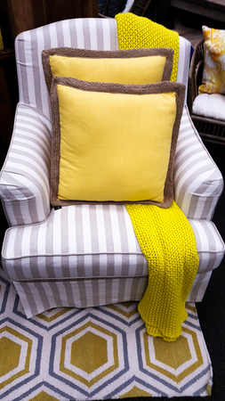 Chair with bright yellow throw and cushion の写真素材