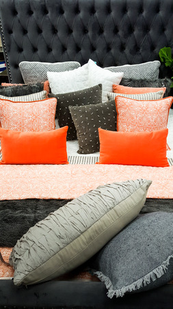 Bed furnishings with mix of cushions throw and pillowsの写真素材