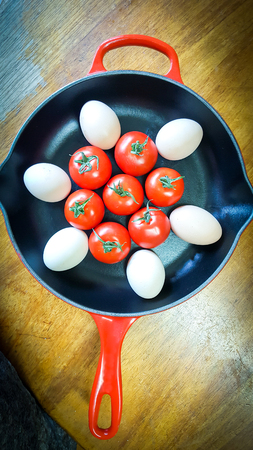 Tomatoes and eggs in a frying panの写真素材