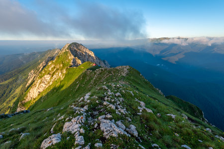 sunrise with haze from the Piatra Craiului mountain range in the Romanian Carpathians with mountains in the background bivouacの写真素材