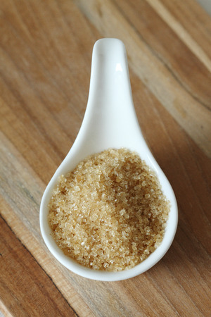 Sugar in ceramic spoon on wooden table. selective focusの写真素材