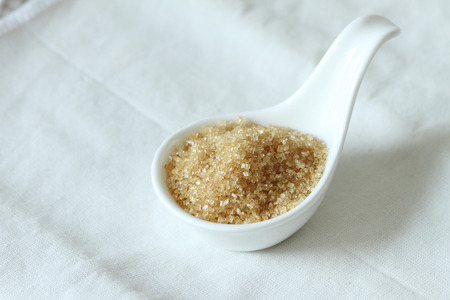 Sugar in ceramic spoon on white background. selective focusの写真素材