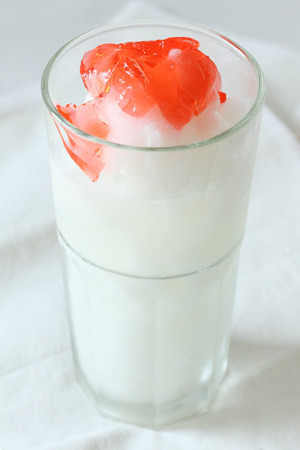 a glass of lime smoothies drinks with red jellyの写真素材