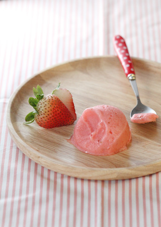 sherbet ice cream on wooden plate with strawberryの写真素材