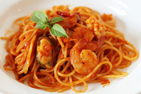 spicey seafood spaghetti on white plateの写真素材