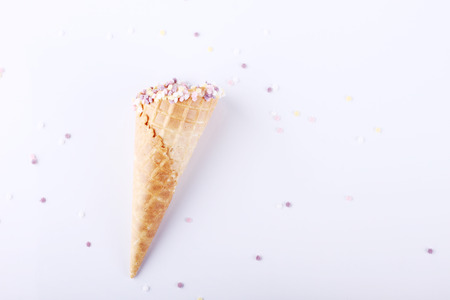 empty ice cream cones with colorful sprinkles on white backgroundの写真素材