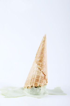 green tea ice cream cones dropped upside down on white backgroundの写真素材