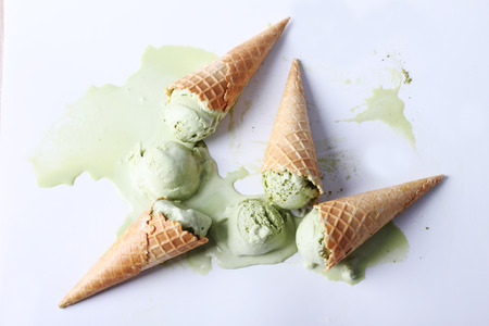 green tea ice cream cones dropped on white backgroundの写真素材
