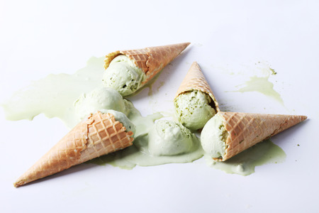green tea ice cream cones dropped on white backgroundの写真素材