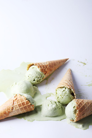 green tea ice cream cones dropped on white backgroundの写真素材