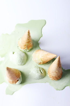 green tea ice cream cones dropped upside down on white backgroundの写真素材