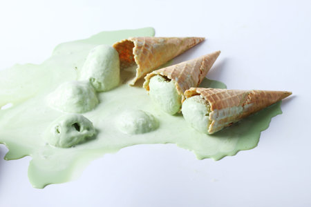 green tea ice cream cones dropped on white background