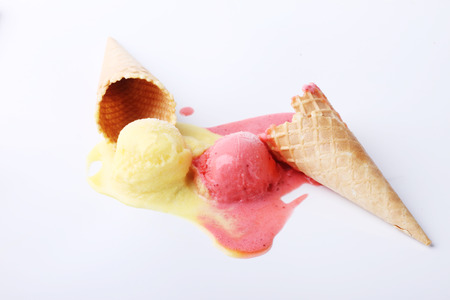 yellow passion fruit and red strawberry ice cream dropped melt on white backgroundの写真素材