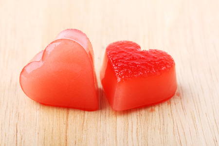 two red heart-shaped ice from raspberry syrup on wooden backgroundの写真素材