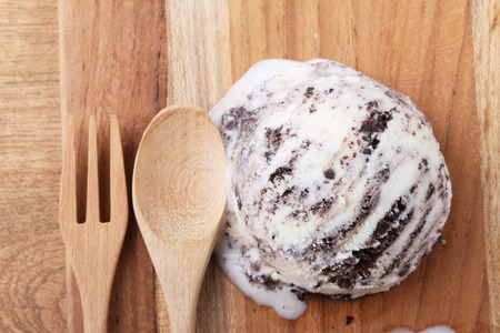 homemade cookie and cream ice cream scoop melting on wooden boardの写真素材