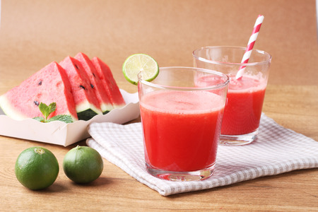 Healthy watermelon lime smoothie and fresh watermelon on a wooden backgroundの写真素材