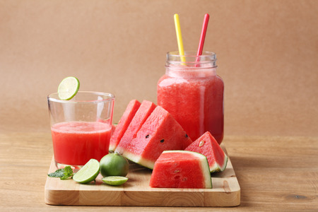Healthy watermelon lime smoothie and fresh watermelon on a wooden backgroundの写真素材