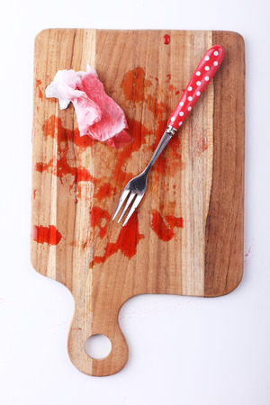red melting ice from raspberry syrup with silver fork on wooden boardの写真素材