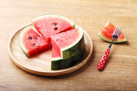 Slices of fresh watermelon on wooden backgroundの写真素材