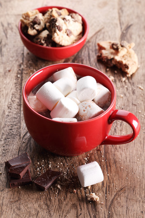 hot chocoalte drink with marshmallows and chocolate pieces on wooden tableの写真素材