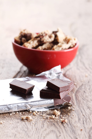 chocolate pieces and cookies in a red cup on wooden tableの写真素材
