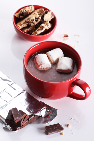hot chocoalte drink with marshmallows and chocolate pieces on white backgroundの写真素材