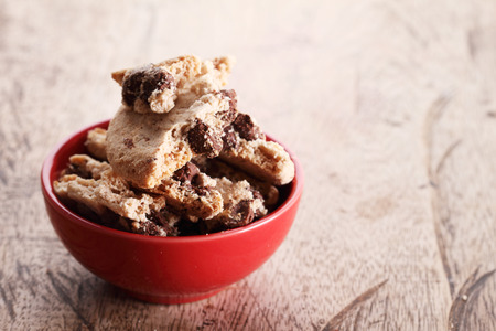 chocolate cookies in a red cup on wooden tableの写真素材