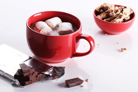 hot chocoalte drink with marshmallows and chocolate pieces on white backgroundの写真素材