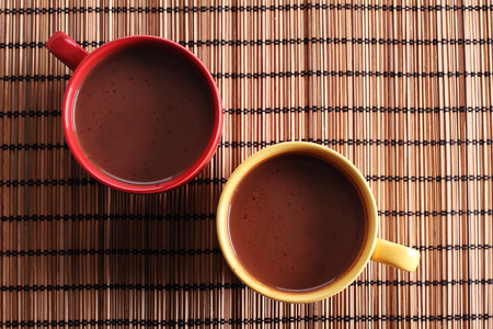 hot chocolate drink in colorful cups on wooden backgroundの写真素材