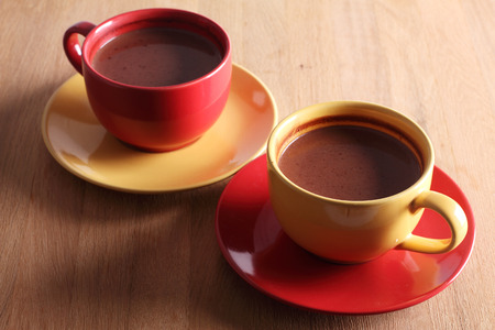 hot chocolate drink in colorful cups on wooden backgroundの写真素材
