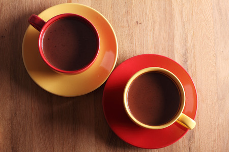 hot chocolate drink in colorful cups on wooden backgroundの写真素材