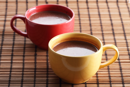 hot chocolate drink in colorful cups on wooden backgroundの写真素材