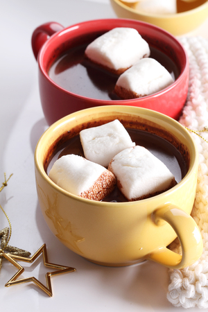 chocolate drink in yellow cup and marshmallows on white backgroundの写真素材