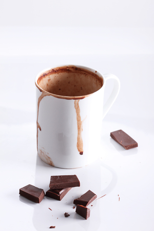 hot chocolate drink in mug with chocolate pieces on white backgroundの写真素材