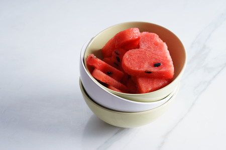pieces of heart shape watermelon on white marble table with copyspaceの写真素材