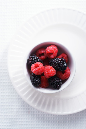 raspberries and black berries. fresh berries on white backgroundの写真素材