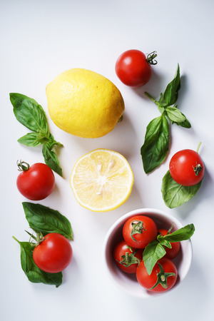 Tomatoes. red ripe tomatoes and basil leaves.の写真素材