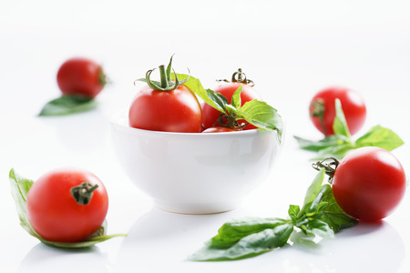 Tomatoes. red ripe tomatoes and basil leaves.の写真素材