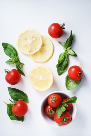 Tomatoes. red ripe tomatoes and basil leaves.の写真素材
