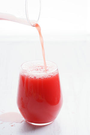 Healthy watermelon drink pouring into a glassの写真素材
