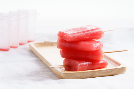 Homemade watermelon popsicles on wooden plate on white backgroundの写真素材