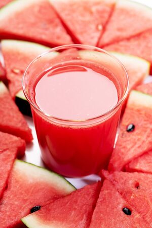 Healthy watermelon drink and fresh sliced watermelon on white wooden backgroundの写真素材