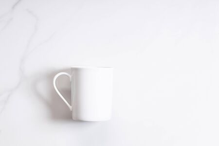 White ceramic cup of hot cocoa on top of white marble backgroundの写真素材