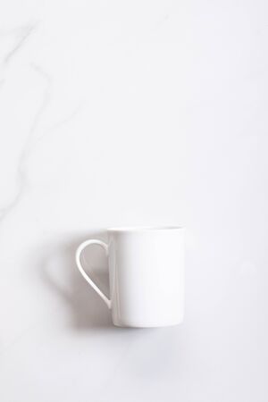 White ceramic cup of hot cocoa on top of white marble backgroundの写真素材