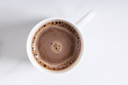 White ceramic cup of hot cocoa on top of white marble background, top viewの写真素材