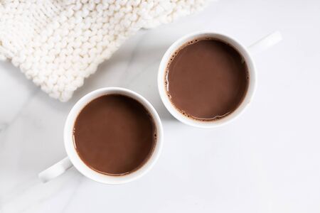 White ceramic cups of hot cocoa on top of white marble background, top viewの写真素材